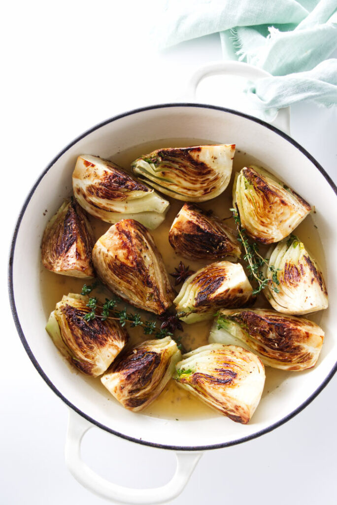 A skillet filled with wedges of fennel.