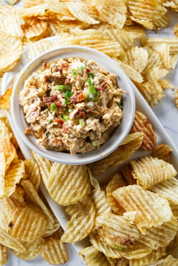 Smoked gouda dip surrounded by potato chips.