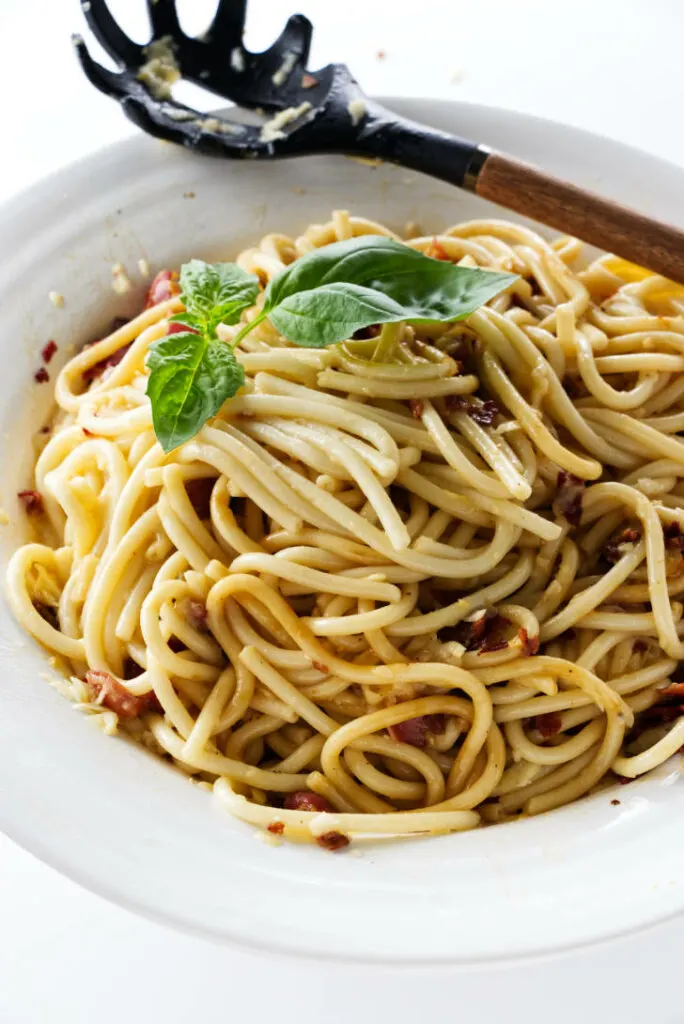 A serving dish filled with bucatini carbonara.