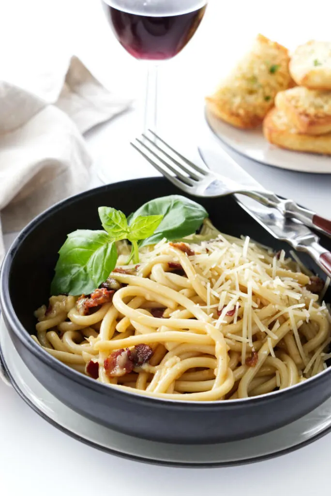 Bucatini carbonara in a pasta bowl.