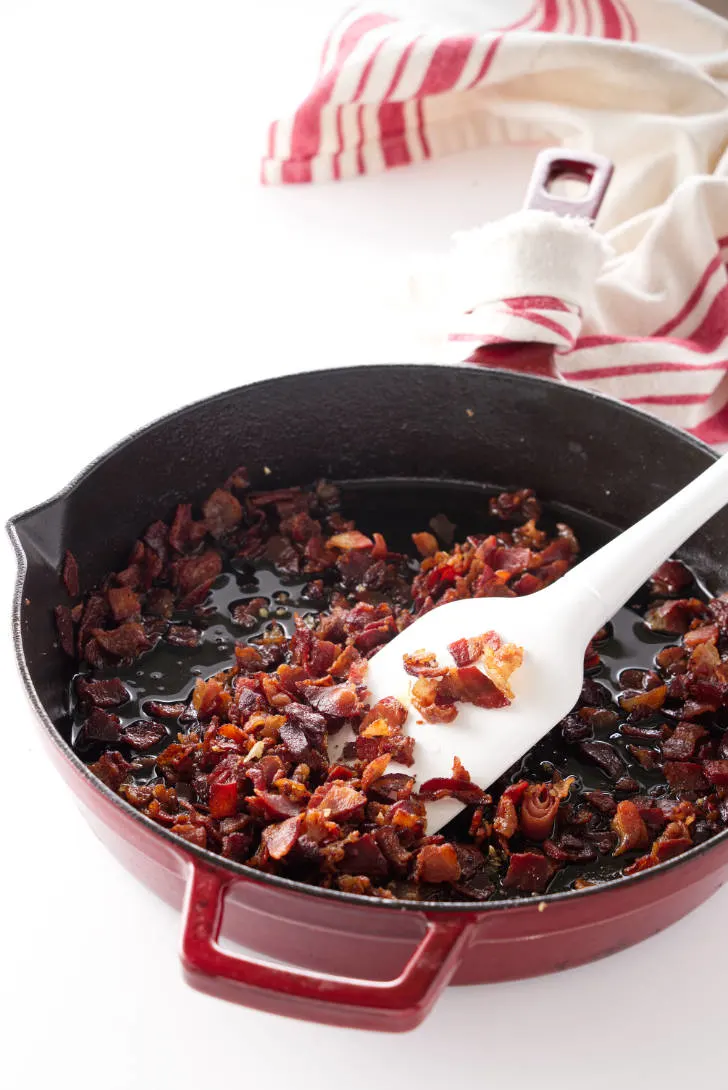 Frying pancetta in a saucepan.