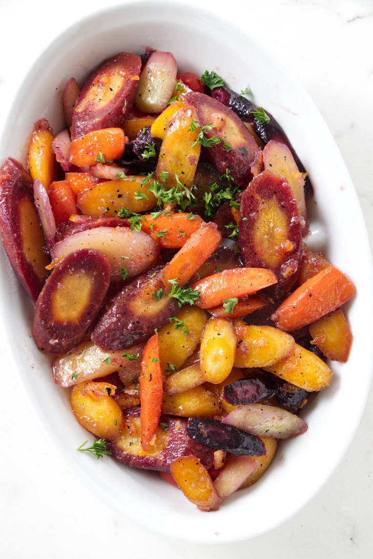 Glazed rainbow carrots in a serving dish.