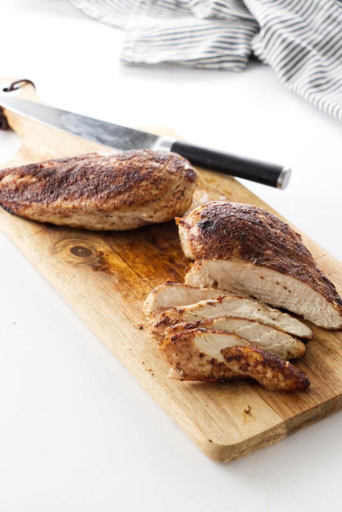 Jerk chicken breasts on a cutting board