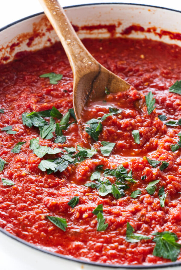 A spoon scooping up tomato sauce.