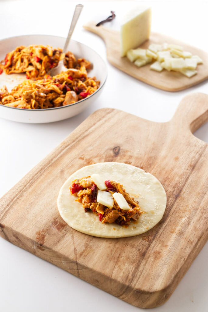 partially completed chicken empanada on a board