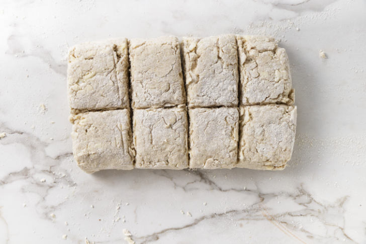 Slicing biscuit dough into squares.