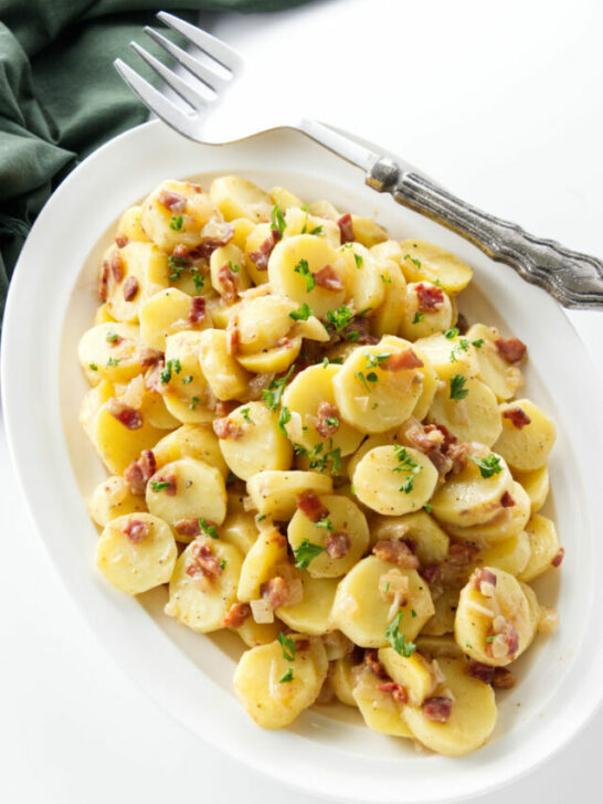 A serving dish with German potato salad with bacon.