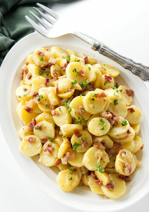 A serving dish with German potato salad with bacon.