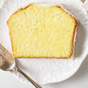 A slice of lemon pound cake with lemon icing on top.