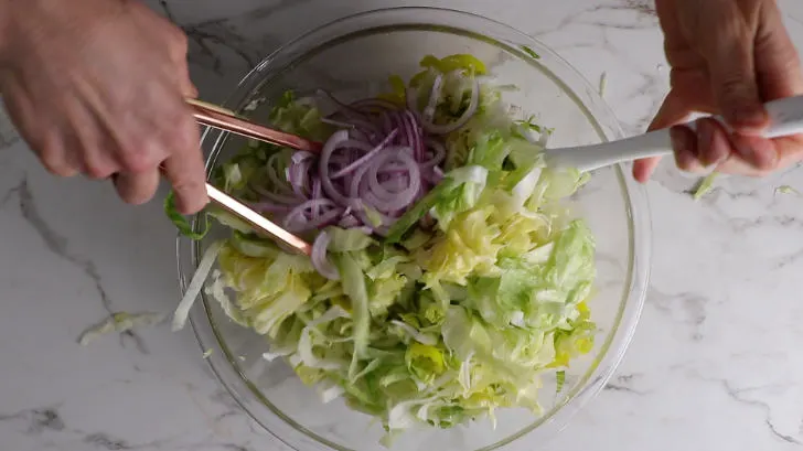 Making a grinder salad for a sandwich.