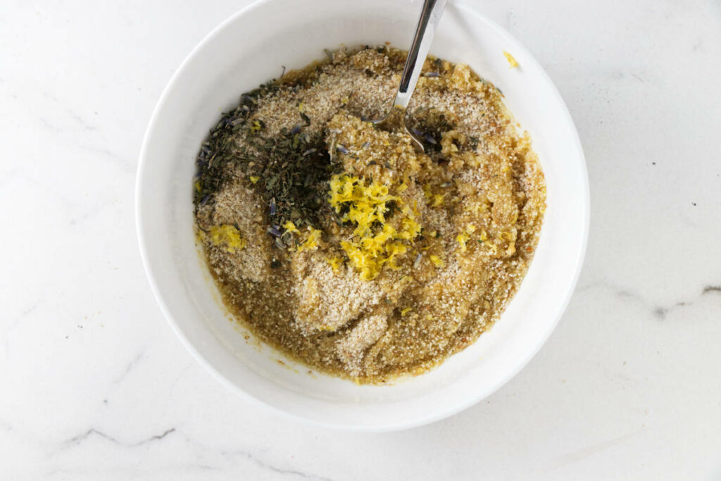 Mixing bread crumbs with oil and herbs.