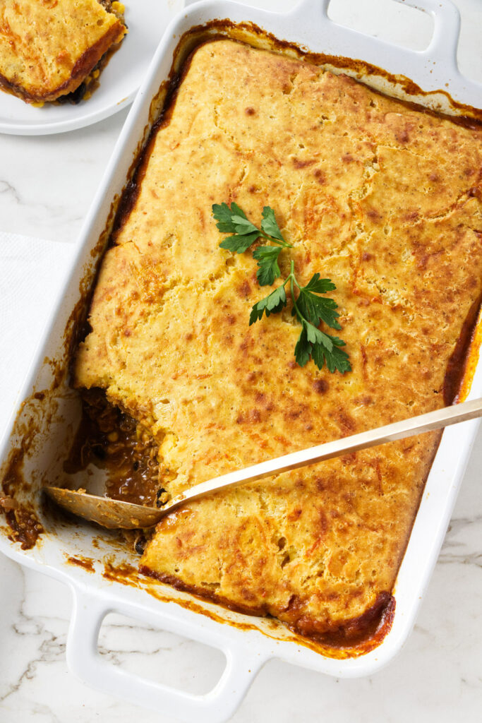 A spoon scooping a serving of chicken casserole.