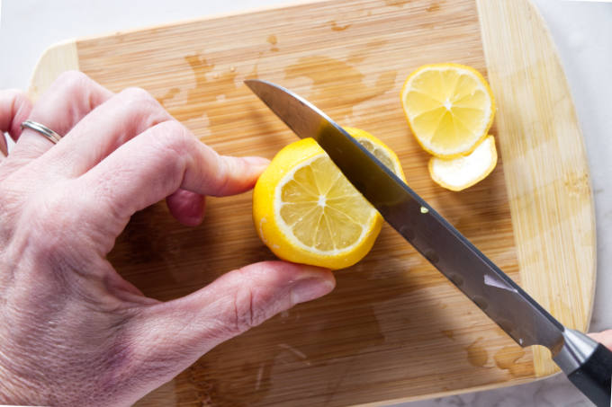 Slicing the peel away from a lemon.