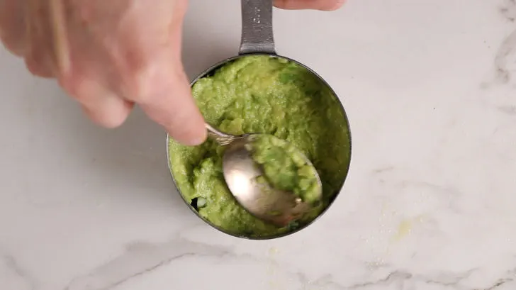 Adding avocado to a mold.