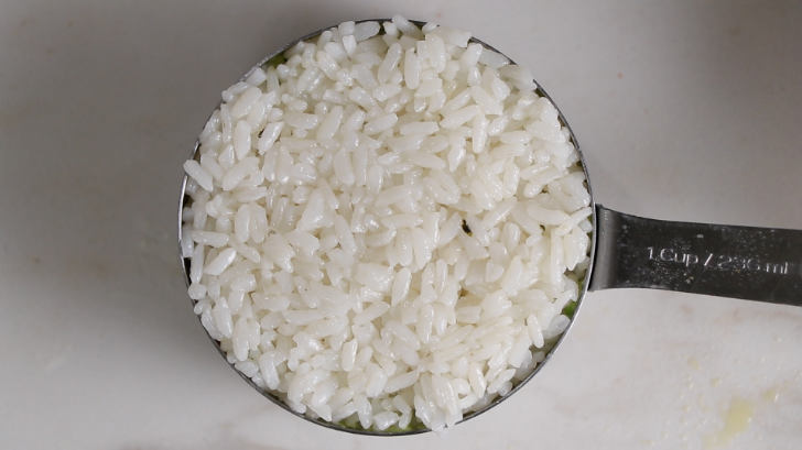 adding sushi rice to a mold.