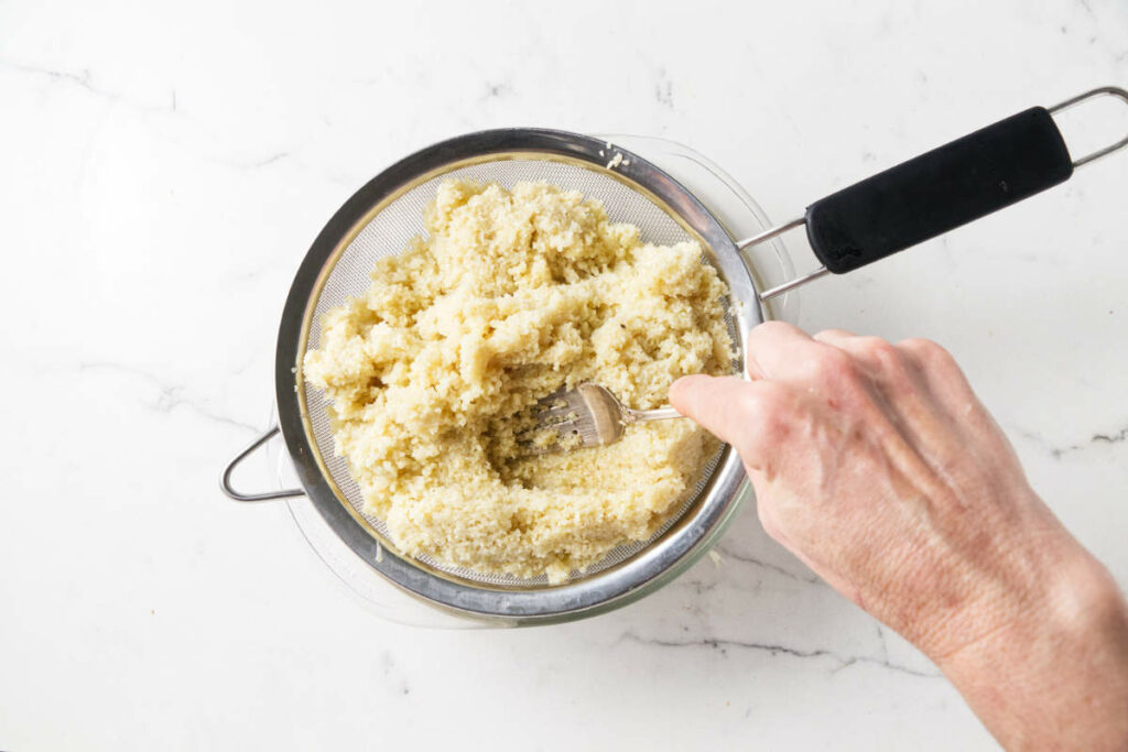 Draining the liquid out of bulgur after soaking it.