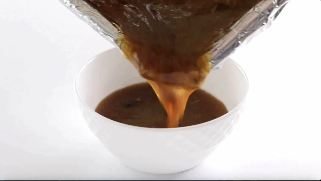 Pouring sauce into a bowl.