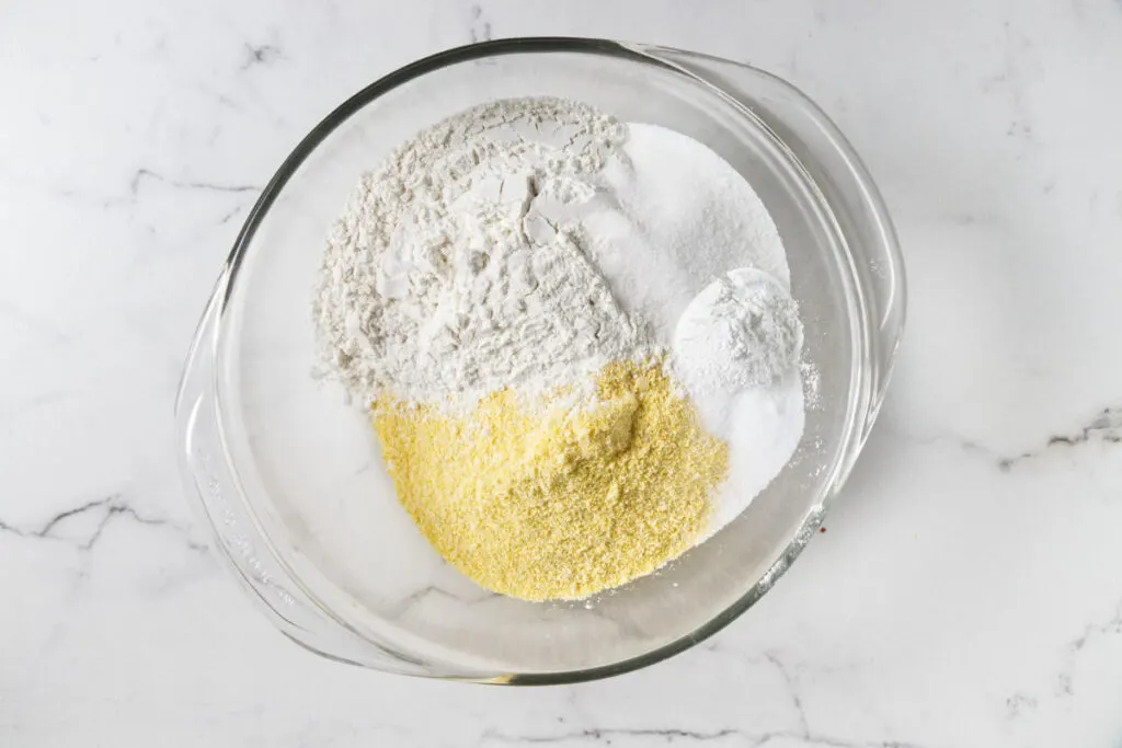 Mixing flour and cornmeal in a bowl.