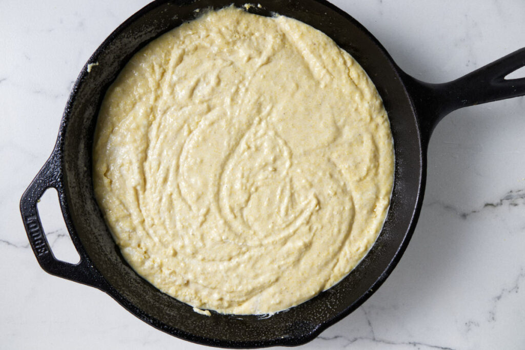 Cornbread batter in a cast iron skillet.