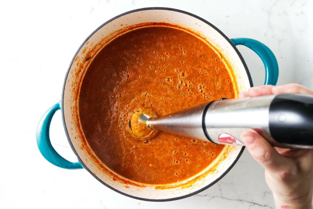 Using a stick blender to puree soup.