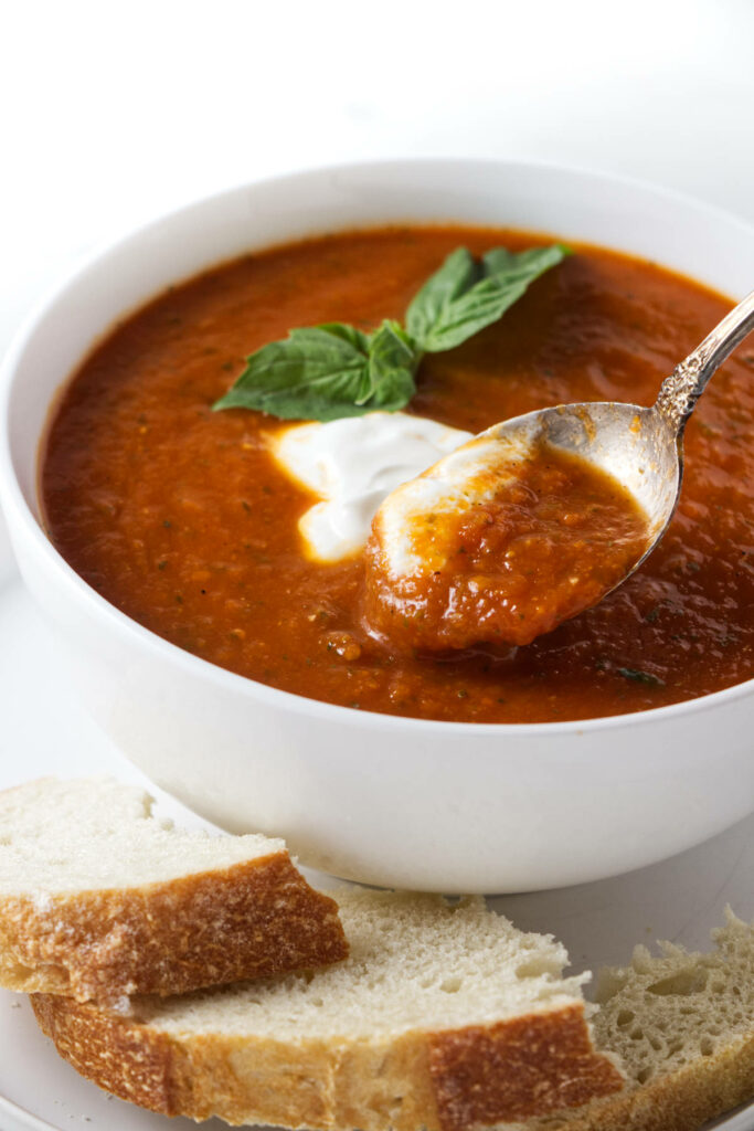 A spoon in a bowl of tomato soup.
