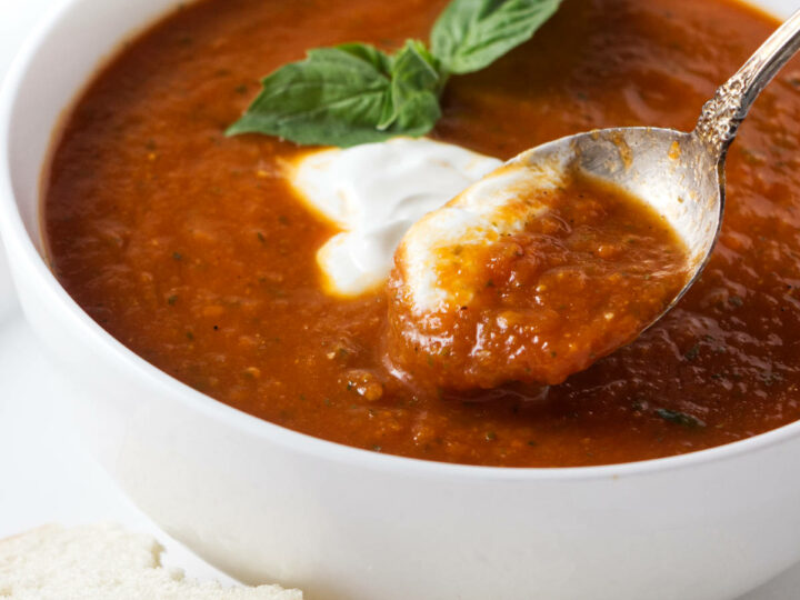A spoon in a bowl of tomato soup.