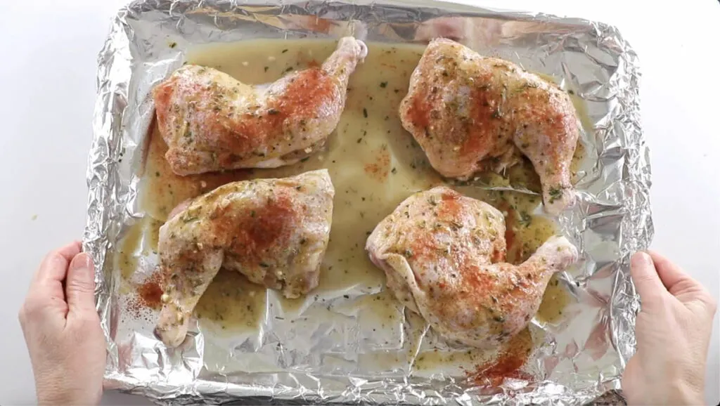 Transferring a pan of chicken to the oven.