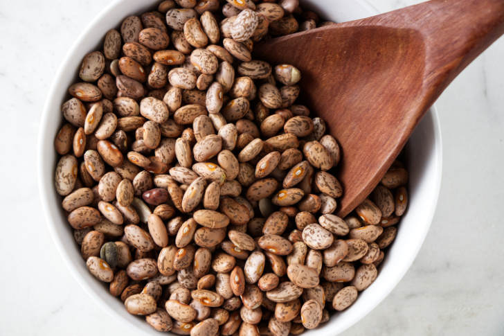 A dish filled with dried pinto beans.