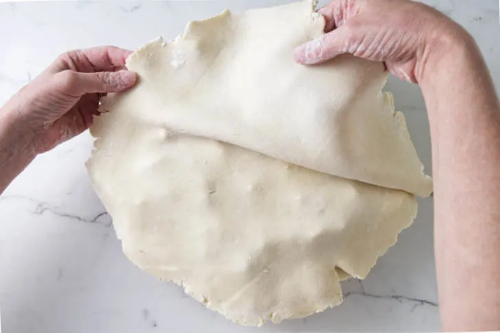 Putting the top crust on a pie.