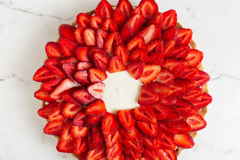Slices of strawberries fanned out on a tart.