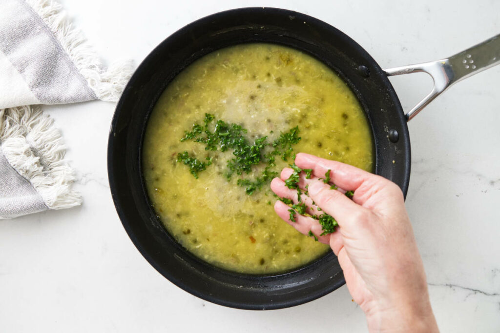 Adding parsley to lemon piccata sauce.