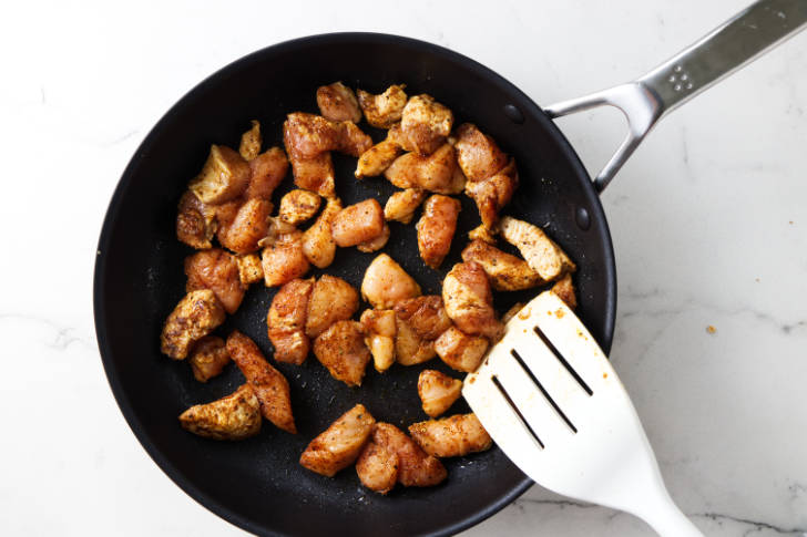 Cooking chicken in a skillet.