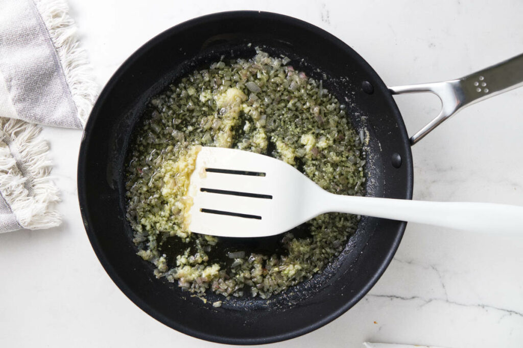 Sautéing onions and garlic in a skillet.