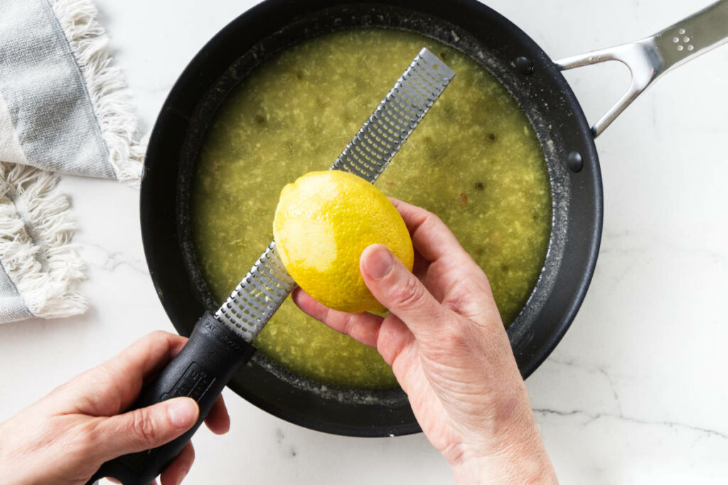 Adding lemon zest to piccata sauce.