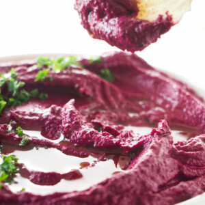 Dipping a cracker in beet hummus.