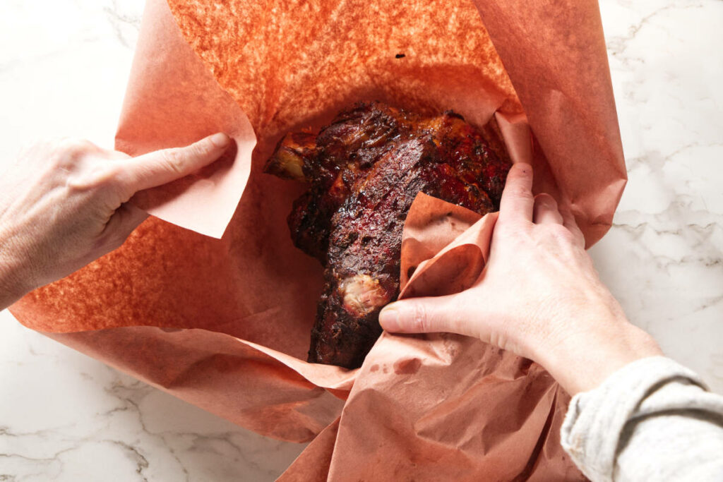 Wrapping pork shoulder in butcher's paper.