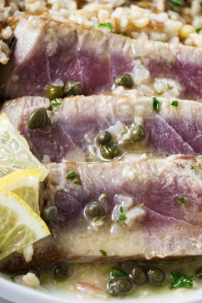 Slices of tuna steak with lemon caper sauce.