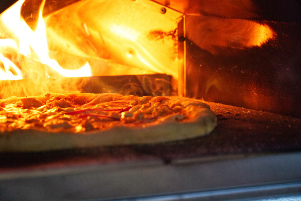 Baking a pizza in an outdoor pizza oven.