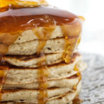 Syrup running down a stack of pancakes.