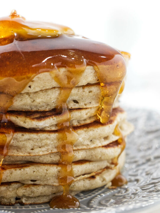 Syrup running down a stack of pancakes.