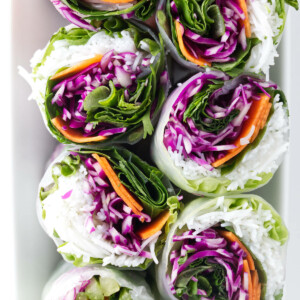 Spring rolls sliced in half to show the colorful interior.