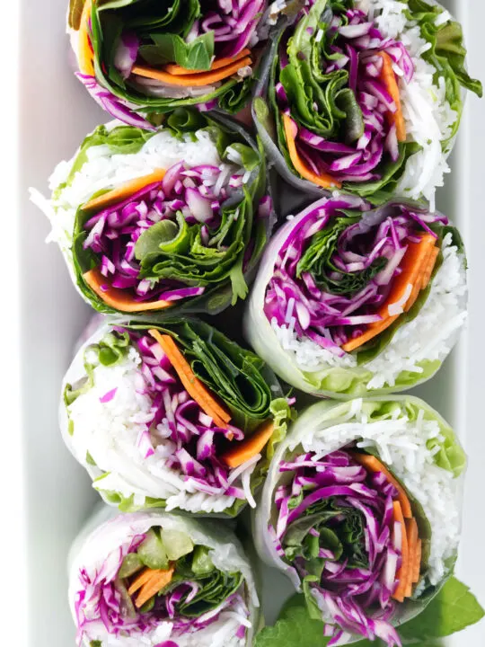 Spring rolls sliced in half to show the colorful interior.