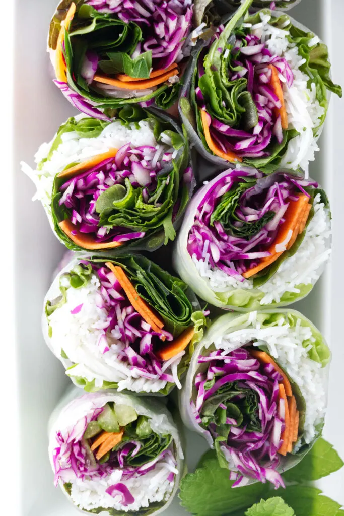 Spring rolls sliced in half to show the colorful interior.