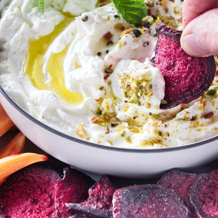 Dipping a beet chip in labneh spread.