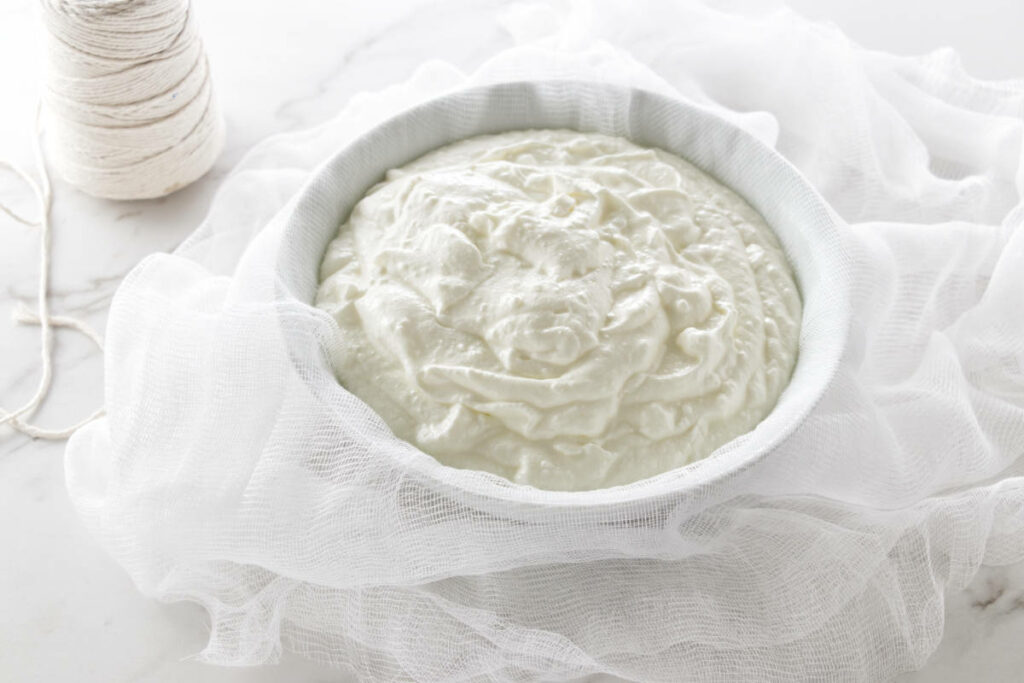 Yogurt in a bowl with cheesecloth.