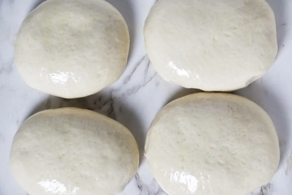 Four balls of Ooni pizza dough.