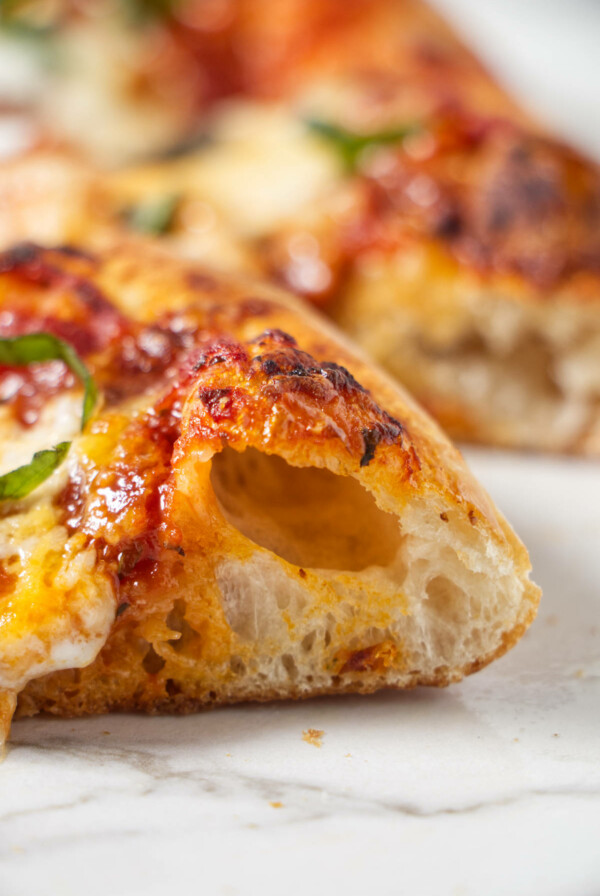 A close up of a pizza crust baked in a pizza oven.