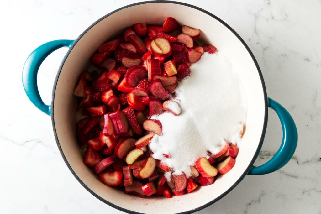 Adding sugar, salt, and lemon juice to the fruit.