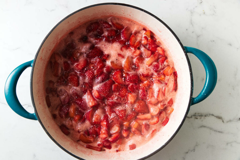 Foam forming on the top of jam as it simmers.