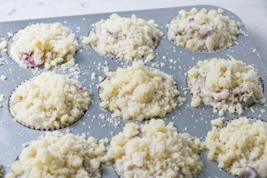 Adding streusel topping on muffins.